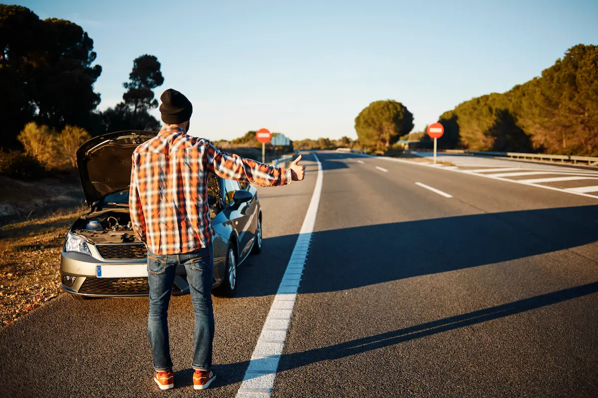 man-standing-his-broken-car